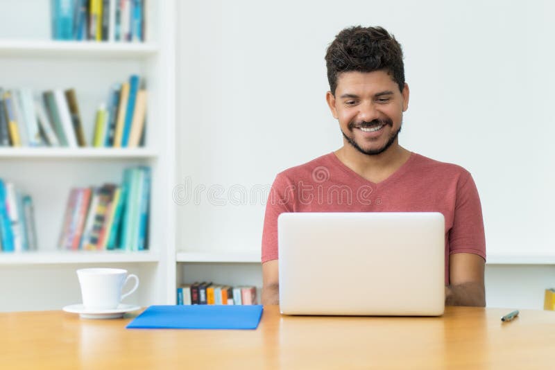 Bărbat matur hispanic cu barbă la apel video la calculator stock image