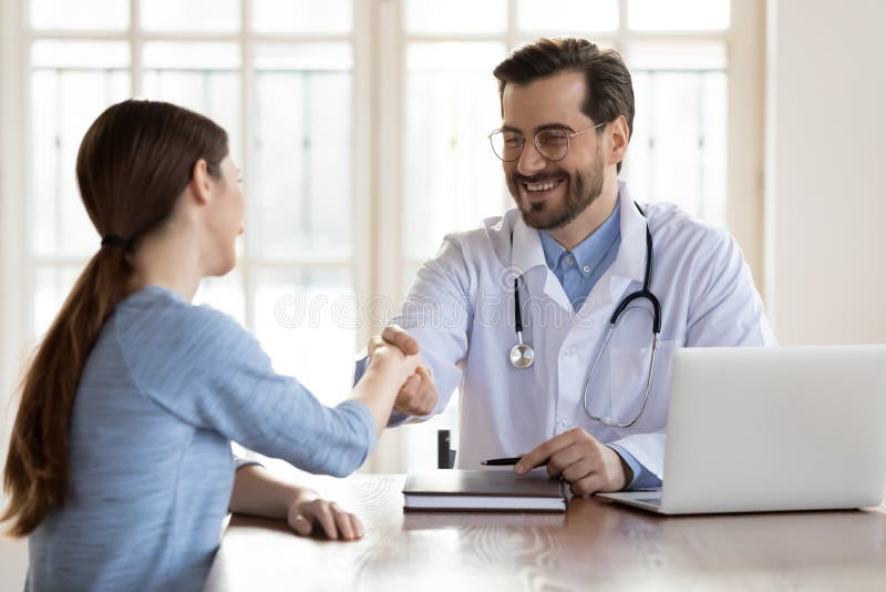 Bărbat zâmbitor, bărbat, care dă mâna pacientei din spital royalty free stock images