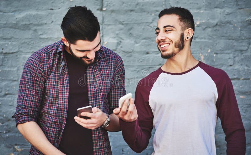 Bărbați care râd de ziduri sau prieteni cu telefon pentru știri online sau știri despre pauze în orașul urban. verificare royalty free stock photos