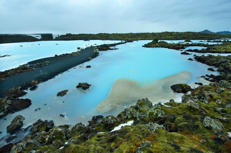 The blue water between the lava stones covered with moss just outside the Blue Lagoon resort of Iceland. The blue water between the lava stones covered with moss just outside the Blue Lagoon resort of Iceland