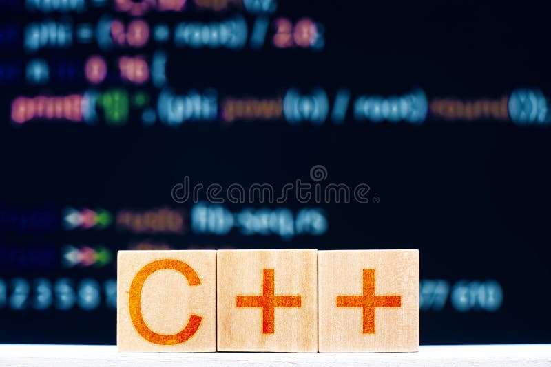 C ++ concept. wooden blocks with the inscription C ++ and program code on the background.