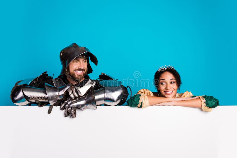 Caballero en armadura y princesa disfrazada sonriendo con un brillante fondo azul foto de archivo libre de regalías