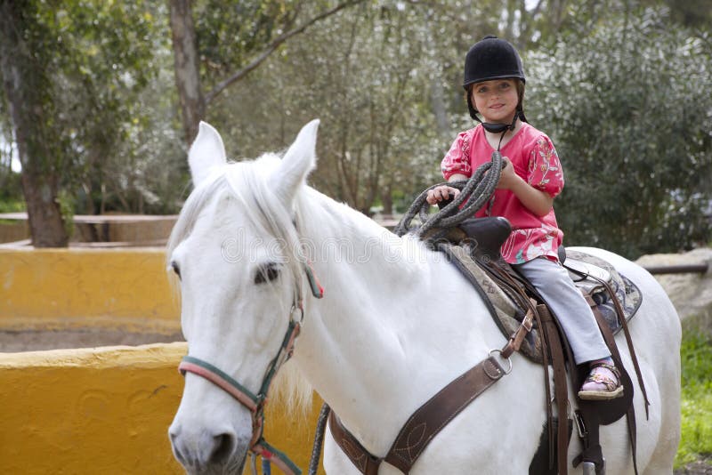 Caballo blanco del sombrero del jinete de la niña del jinete en parque imágenes de archivo libres de regalías Caballo blanco del sombrero del jinete de la niña del jinete en parque imágenes de archivo libres de regalías