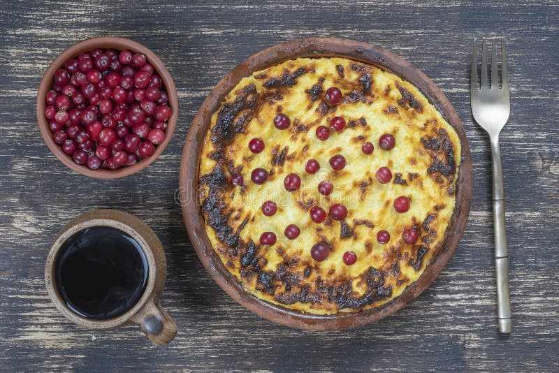Caballo de queso cabaña dulce con pasas y sémola sobre mesa de madera. Cubeta de cerámica con casserole de queso cottage al hor imagenes de archivo Caballo de queso cabaña dulce con pasas y sémola sobre mesa de madera. Cubeta de cerámica con casserole de queso cottage al hor imagenes de archivo