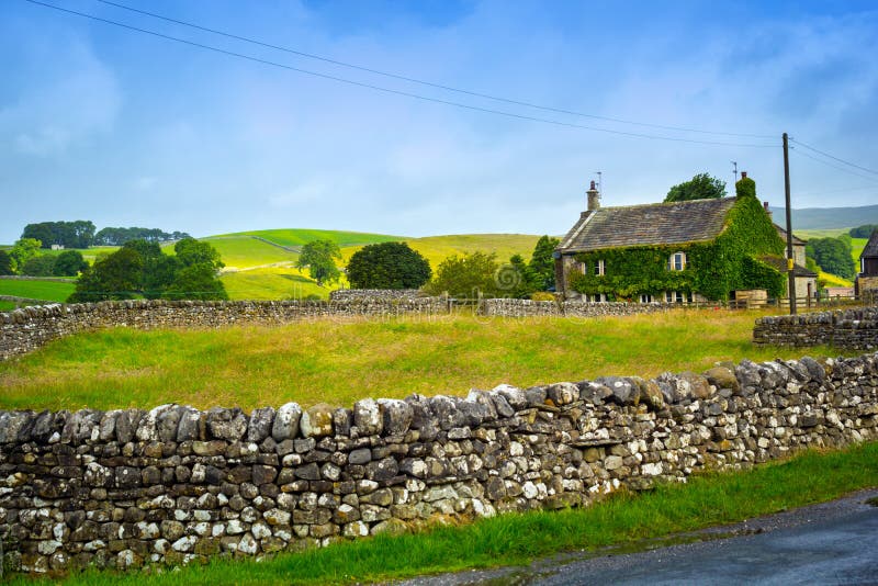 Casa Vieja Inglesa Con El Jardín De La Pared De Piedra Foto de archivo - Imagen de británico