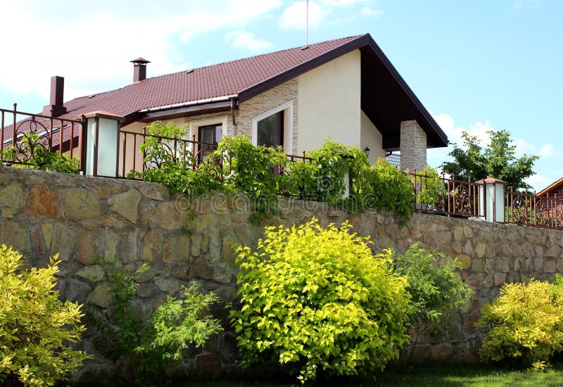 Cabaña residencial moderna hermosa de la casa de campo con la cerca y ajardinar imágenes de archivo libres de regalías Cabaña residencial moderna hermosa de la casa de campo con la cerca y ajardinar imágenes de archivo libres de regalías