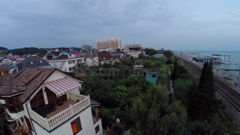 Cabañas en la ciudad costera con ferrocarril cerca del mar almacen de metraje de vídeo