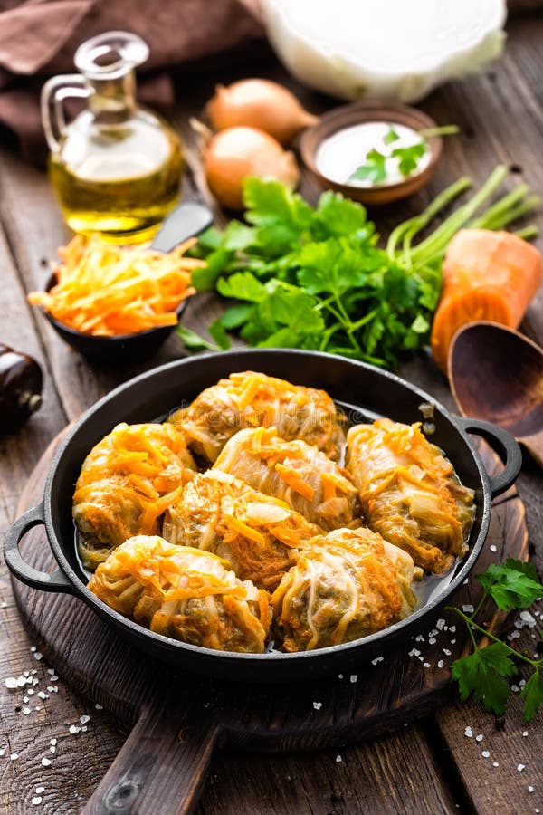 Cabbage rolls stewed with meat and vegetables in pan on dark wooden background royalty free stock image Cabbage rolls stewed with meat and vegetables in pan on dark wooden background royalty free stock image