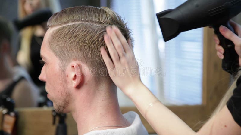 O Cabeleireiro Da Mulher Que Faz a Moderno O Corte De Cabelo Masculino Para  O Meio Envelheceu O Homem Com a Lâmina Elétrica E O P Filme - Vídeo de  habilidade, penteado: 119658502