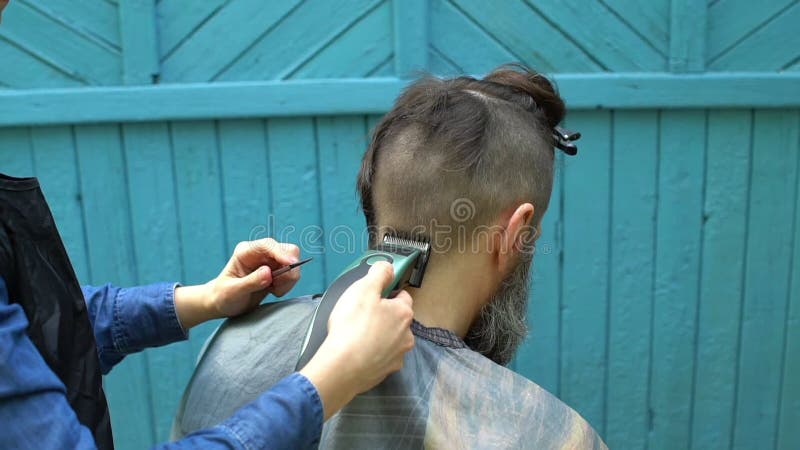 Cabeleireiro Fêmea Que Faz O Corte De Cabelo Masculino Com a