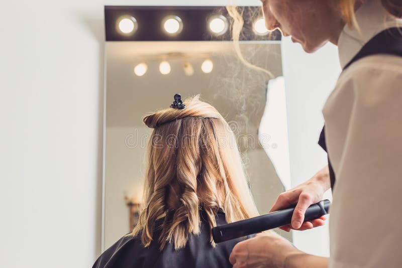 Cabeleireiro que faz um penteado para o cliente fotografia de stock Cabeleireiro que faz um penteado para o cliente fotografia de stock