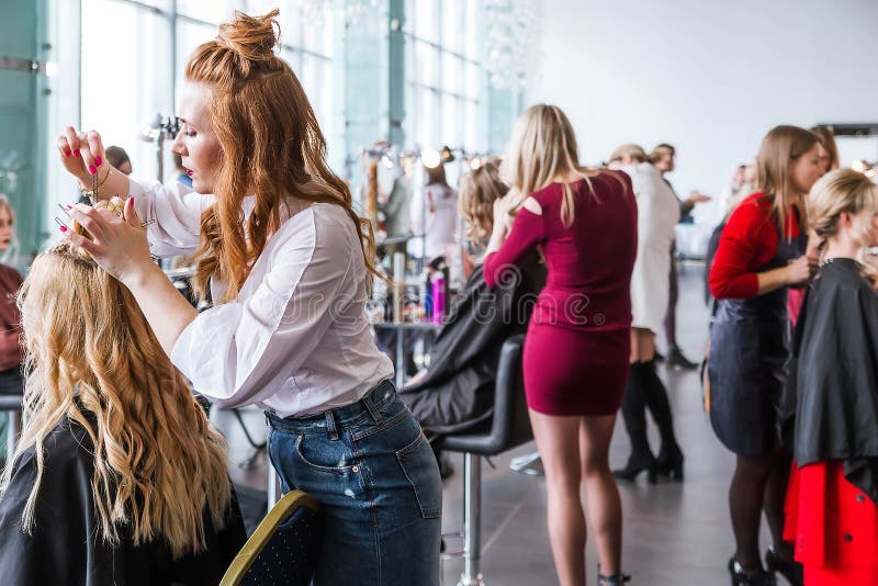 Cabeleireiros da competição na exposição de penteados e maquiagem. cabeleireiro cria penteado fotos de stock