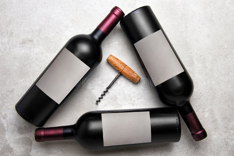 Cabernet Wine: Overhead view of a group of three bottles with blank labels arranged in a triangle with a corkcscrew in the middle royalty free stock photos