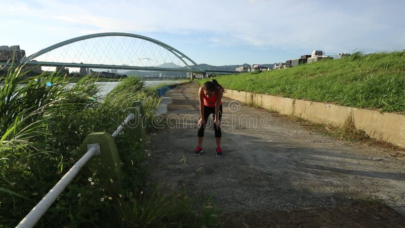 Caberá a jovem asiática descansando depois de correr perto do rio na cidade de taipe