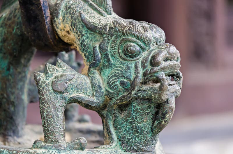 Bronze ancient dragon head in in vietnamese buddha temple. It's covered with a greenish old patina. Bronze ancient dragon head in in vietnamese buddha temple. It's covered with a greenish old patina.