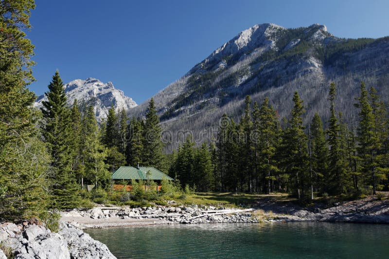 Cabin and Mountain on Lake Minnewanka royalty free stock photography