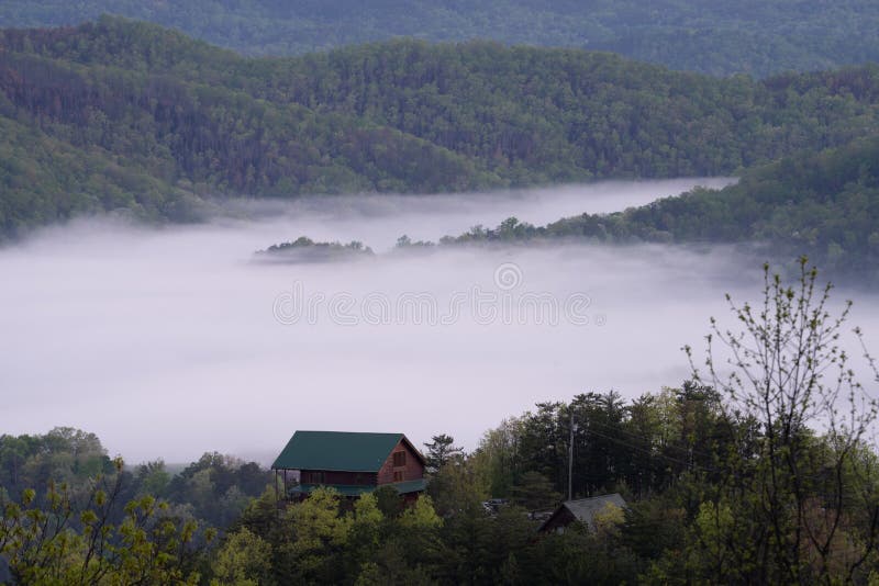 Smoky Mountain cabin surrounded by fog. Cabin during sunrise in the smoky mountains surrounded by fog