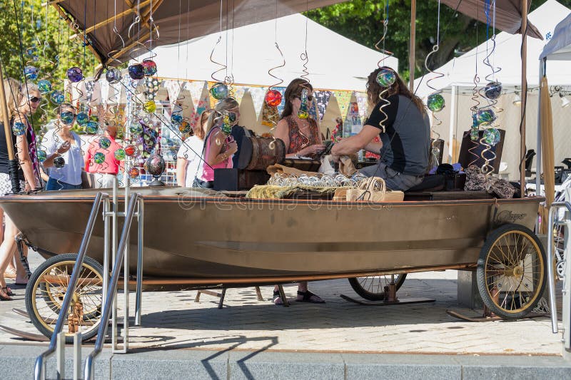 Portland, Oregon, USA - September 20, 2014: A boat is used as a booth to display glass blown balls in spinners at Portland`s Waterfront Saturday Market. Portland, Oregon, USA - September 20, 2014: A boat is used as a booth to display glass blown balls in spinners at Portland`s Waterfront Saturday Market