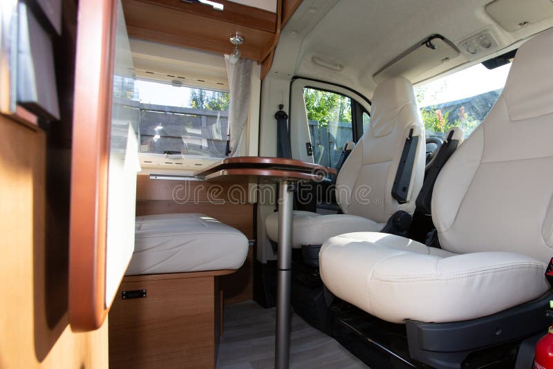 A Camper Cabin Interior traveling in CamperVan with table and white seat in recreational vehicle van for vanlife holidays trip. A Camper Cabin Interior traveling in CamperVan with table and white seat in recreational vehicle van for vanlife holidays trip