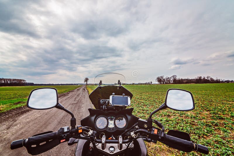 Cabina di pilotaggio del motociclo alla strada non asfaltata fotografia stock libera da diritti Cabina di pilotaggio del motociclo alla strada non asfaltata fotografia stock libera da diritti