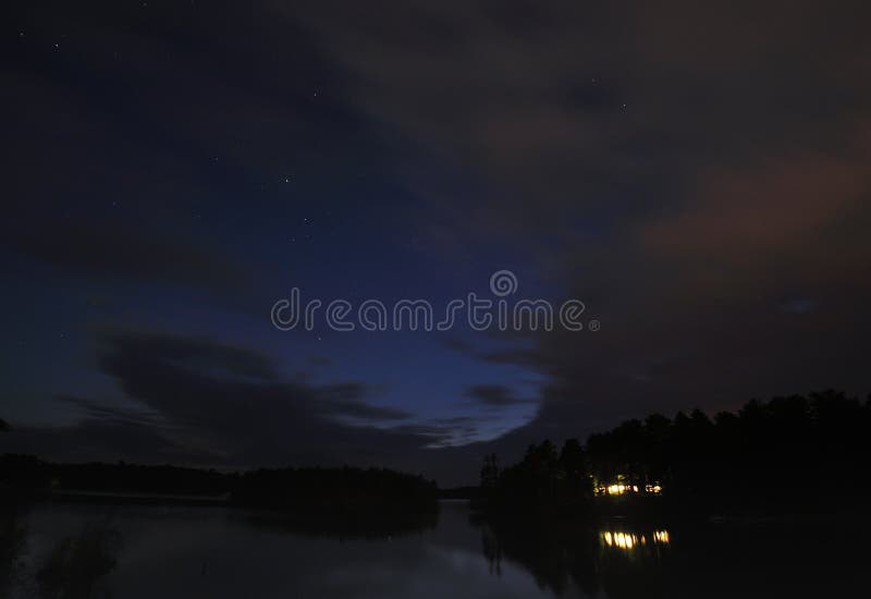 Cabina sul lago alla notte con le stelle fotografia stock Cabina sul lago alla notte con le stelle fotografia stock