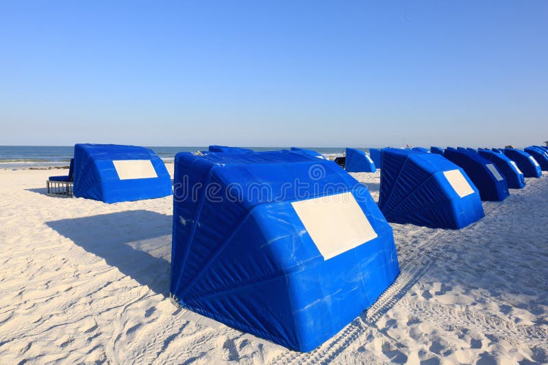 Cabine blu della spiaggia su una spiaggia tropicale della sabbia bianca fotografia stock Cabine blu della spiaggia su una spiaggia tropicale della sabbia bianca fotografia stock