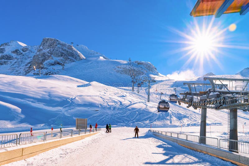 Cable cars and skiers skiing at Hintertux Glacier in Austria