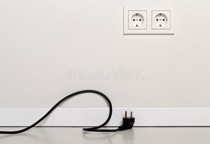 Cable negro del cable eléctrico desenchufado con el enchufe de pared europeo en wh foto de archivo libre de regalías Cable negro del cable eléctrico desenchufado con el enchufe de pared europeo en wh foto de archivo libre de regalías