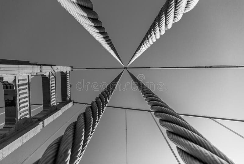 Looking up through the support cables at Golden Gate Bridge support tower in black and white