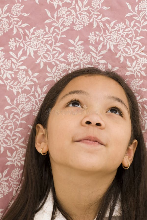 Asian Kid Looking Up Against Floral Background, Thinking or Dreaming. Asian Kid Looking Up Against Floral Background, Thinking or Dreaming