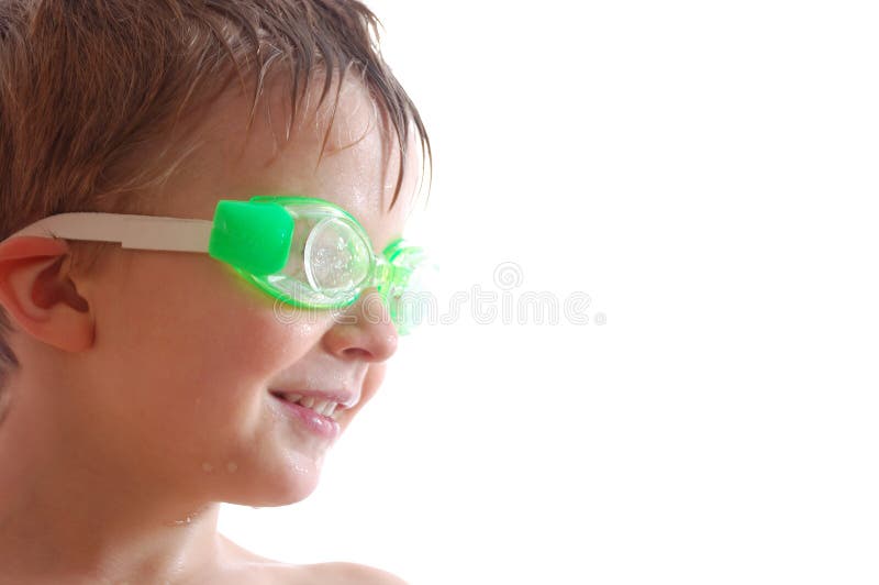 Smiling elementary age boy with wet hair and goggles over white. Smiling elementary age boy with wet hair and goggles over white