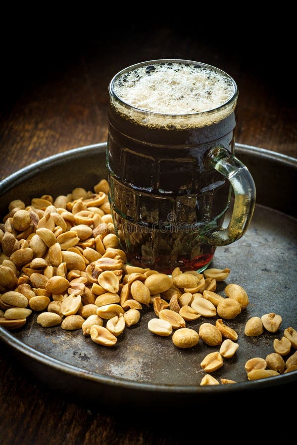 Cacahuetes salados de la cerveza espumosa fotografía de archivo libre de regalías Cacahuetes salados de la cerveza espumosa fotografía de archivo libre de regalías