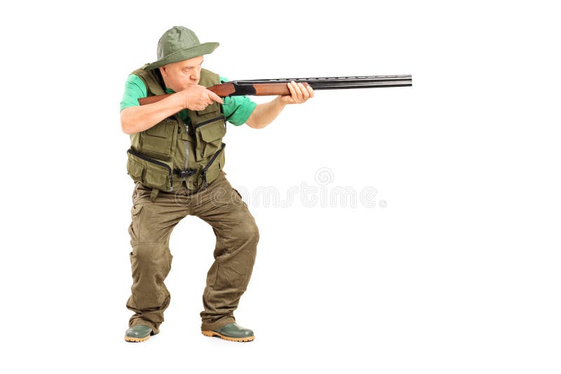 Cacciatore maturo che punta su qualcosa con una pistola fotografie stock Cacciatore maturo che punta su qualcosa con una pistola fotografie stock