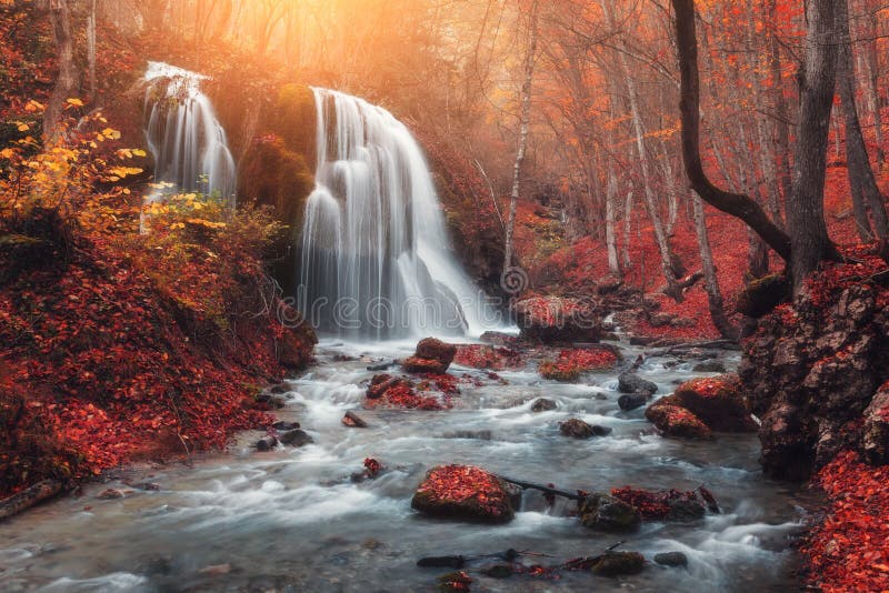 Cachoeira no rio da montanha na floresta do outono no por do sol