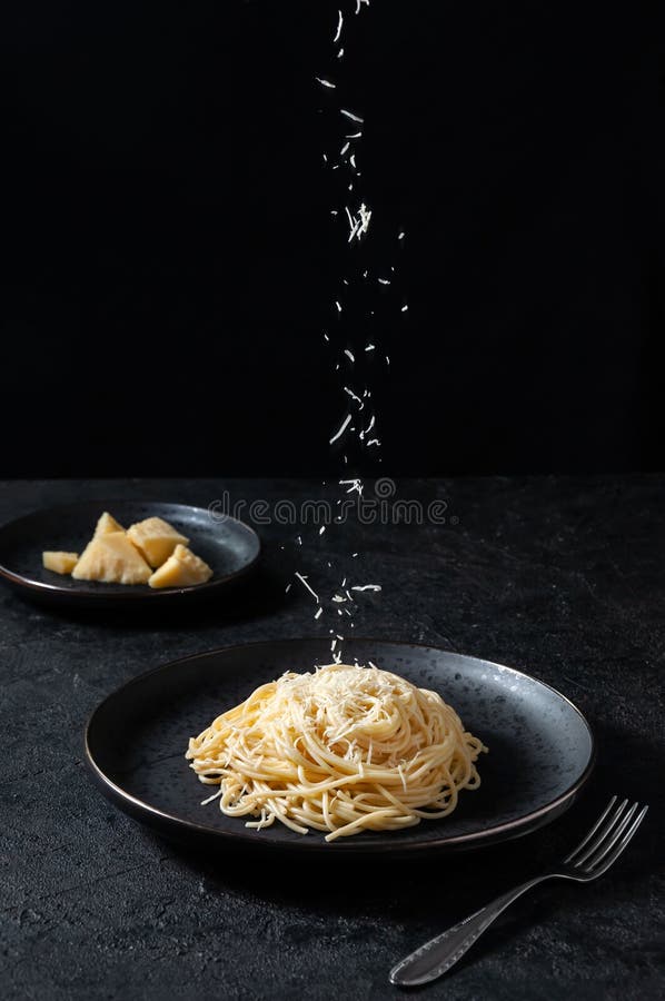 Cacio e Pepe - Italian Pasta with Cheese and Pepper. Spaghetti Sprinkled Cheese on Black Plate on Dark Background royalty free stock photos Cacio e Pepe - Italian Pasta with Cheese and Pepper. Spaghetti Sprinkled Cheese on Black Plate on Dark Background royalty free stock photos
