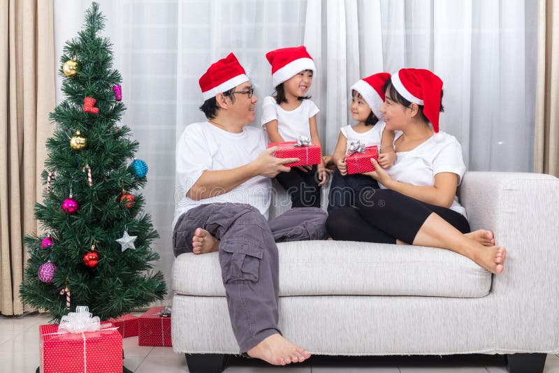 Cadeau chinois asiatique heureux de Noël d'échange de famille à la maison images stock Cadeau chinois asiatique heureux de Noël d'échange de famille à la maison images stock
