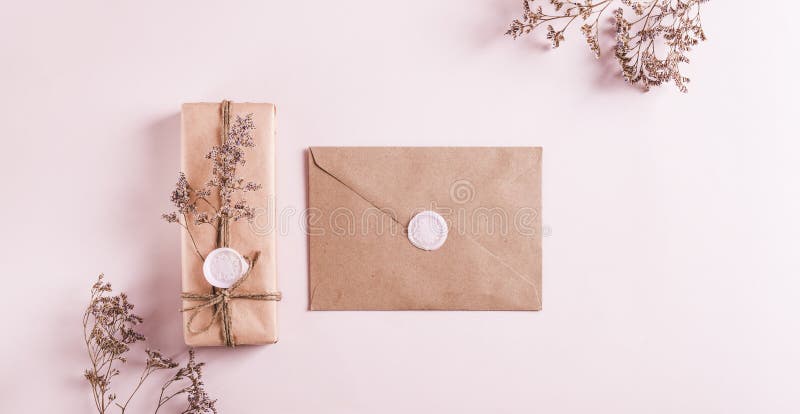 Cadeau en papier kraft et enveloppe avec sceaux de cire et fleurs séchées sur la bannière web vue en haut rose photos stock