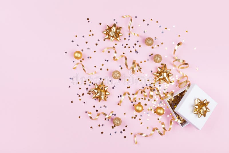 Cadeau ou boîte actuelle avec les étoiles de confettis, le ruban d'or et la décoration de vacances sur le fond rose Configuration images libres de droits Cadeau ou boîte actuelle avec les étoiles de confettis, le ruban d'or et la décoration de vacances sur le fond rose Configuration images libres de droits
