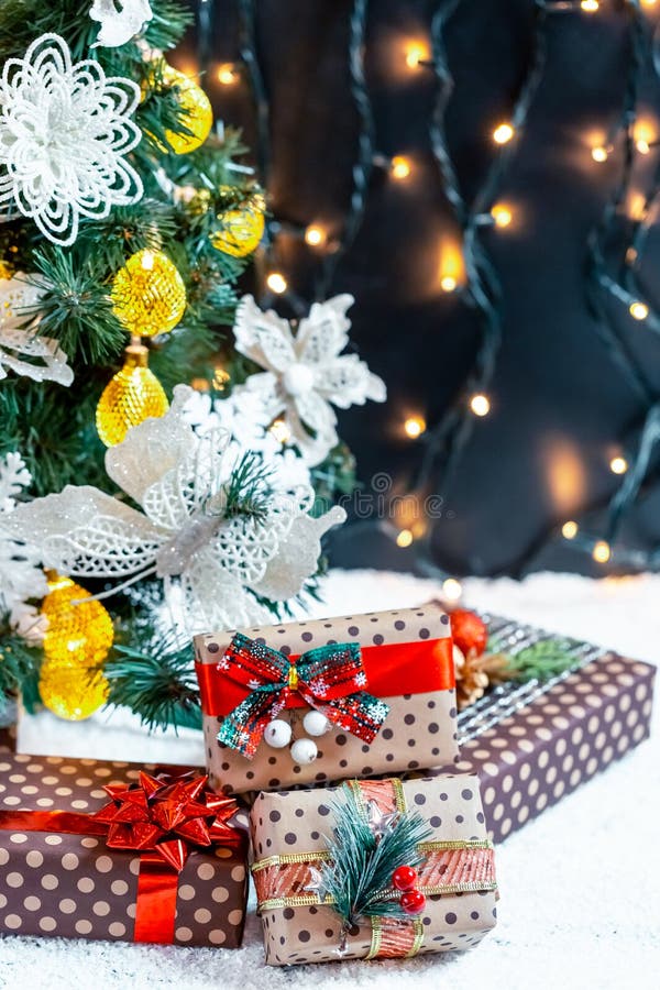 Cadeaux de Noël dans la neige sous l'arbre Le concept des vacances, des surprises et du présent à la maison images stock Cadeaux de Noël dans la neige sous l'arbre Le concept des vacances, des surprises et du présent à la maison images stock