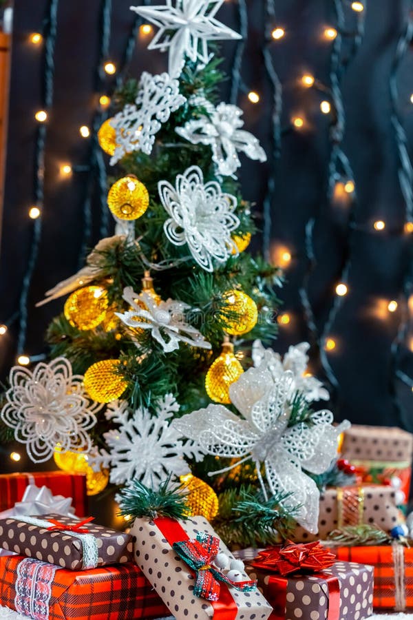 Cadeaux de Noël dans la neige sous l'arbre Le concept des vacances, des surprises et du présent à la maison photo stock Cadeaux de Noël dans la neige sous l'arbre Le concept des vacances, des surprises et du présent à la maison photo stock