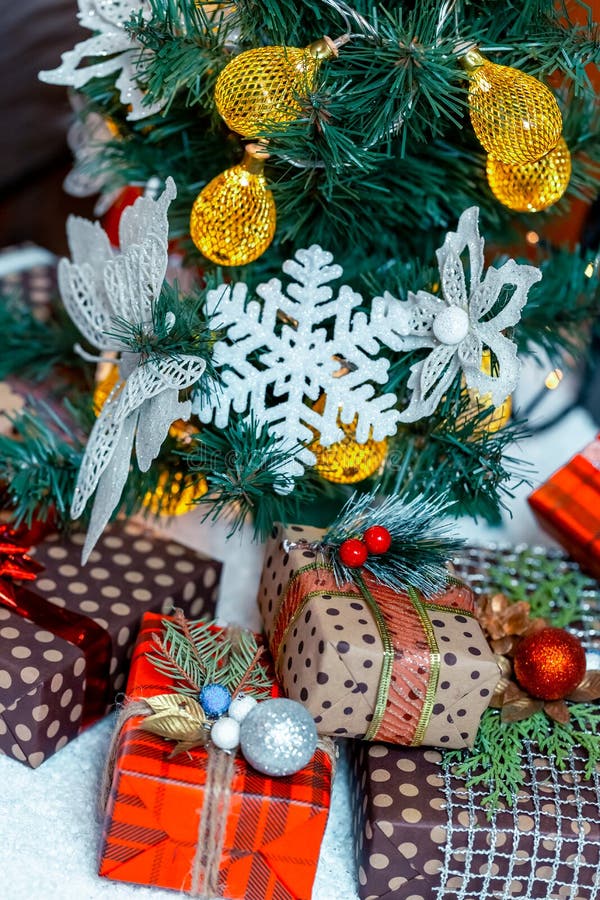 Cadeaux de Noël dans la neige sous l'arbre Le concept des vacances, des surprises et du présent à la maison photographie stock libre de droits Cadeaux de Noël dans la neige sous l'arbre Le concept des vacances, des surprises et du présent à la maison photographie stock libre de droits