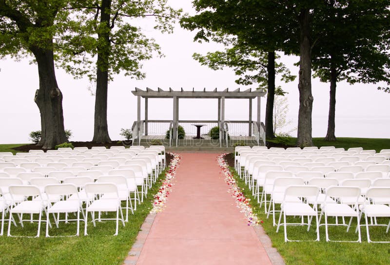 White chairs arranged and setup for a wedding ceremony. White chairs arranged and setup for a wedding ceremony