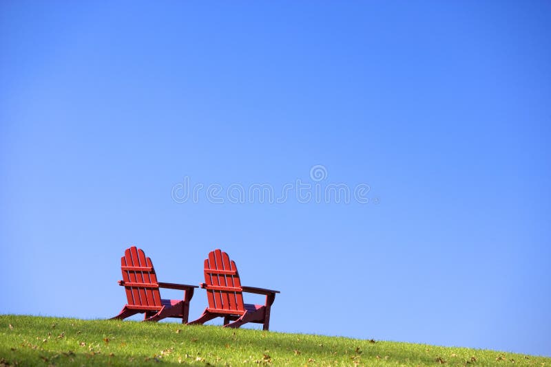 Cadeiras de gramado vermelhas na grama