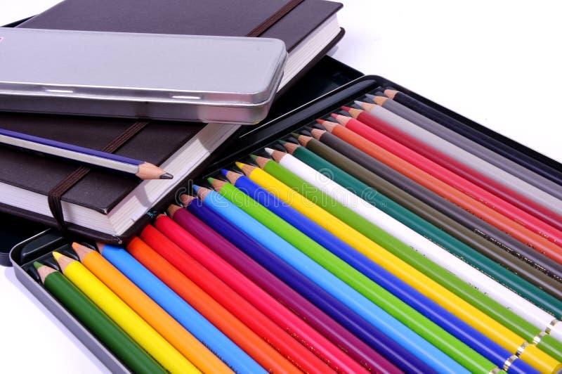 Caderno, lápis preto e lápis colorido