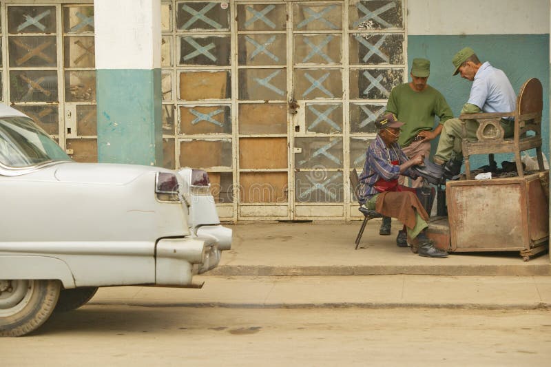Cadillac 1955 devant de vieux magasins et les soldats obtenant une chaussure brillent près de l'EL Rincon, Cuba