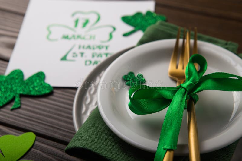 St Patrick`s Day party table setting decorated with green leprechaun on wooden background. St Patrick`s Day party table setting decorated with green leprechaun on wooden background