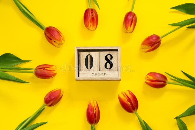 Cadre floral avec les fleurs rouges de tulipe autour du calendrier cubique en bois avec la date du 8 mars Composition en jour des photo libre de droits Cadre floral avec les fleurs rouges de tulipe autour du calendrier cubique en bois avec la date du 8 mars Composition en jour des photo libre de droits