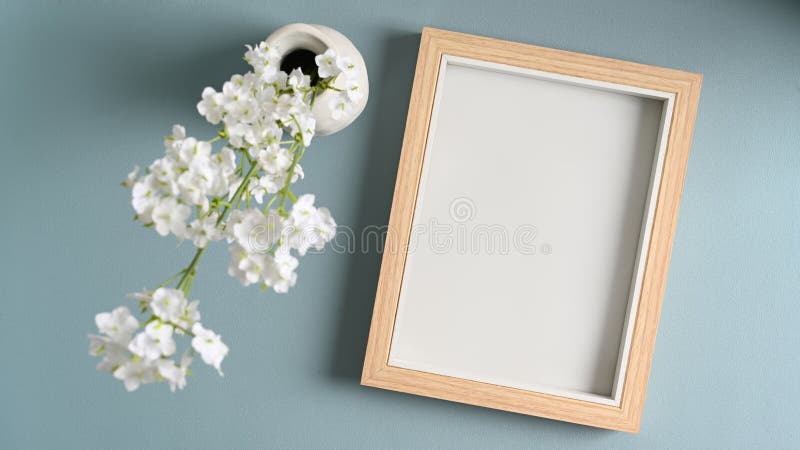 Empty photo frame and  flowers in vases on blue pastes background. Empty photo frame and  flowers in vases on blue pastes background.