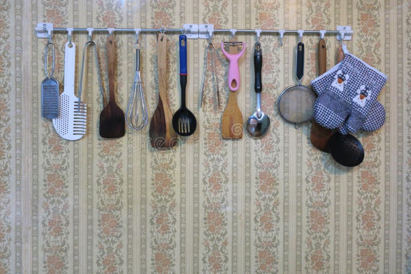 Various cooking tool such as ladle, colander are hanging on the wall. Various cooking tool such as ladle, colander are hanging on the wall