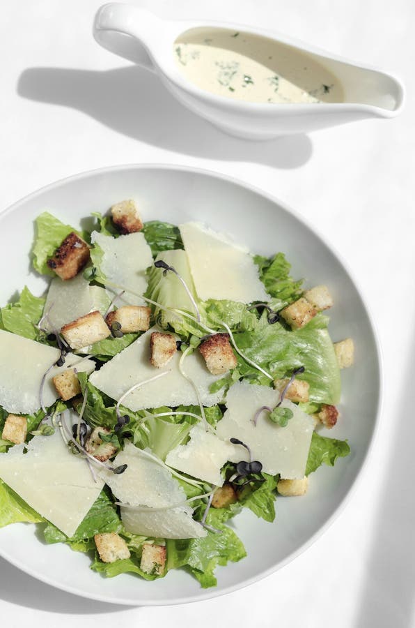 Caesar Salad with Parmesan Cheese and Croutons on Table Stock Photo